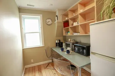 a kitchen with a table with a microwave and a refrigerator at 23Maple in Haliburton