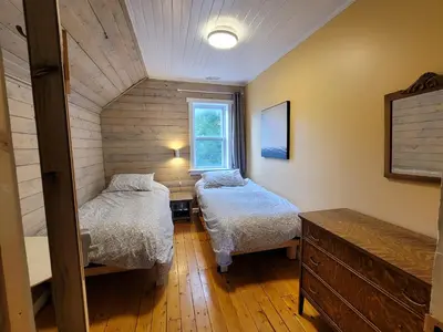 a small room with two beds and a window at 23Maple in Haliburton