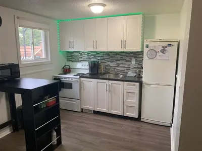 a kitchen with white cabinets and a white refrigerator at Lovely apartment house in Grimsby