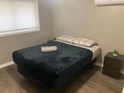 a bed in a room with a black mattress and a window at Lovely apartment house in Grimsby