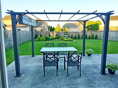 a patio with a table and chairs under a pergola at Home Pearl B&B in Niagara Falls
