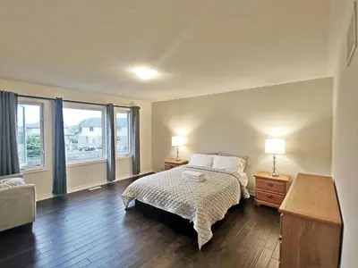 a bedroom with a bed and a large window at Home Pearl B&B in Niagara Falls