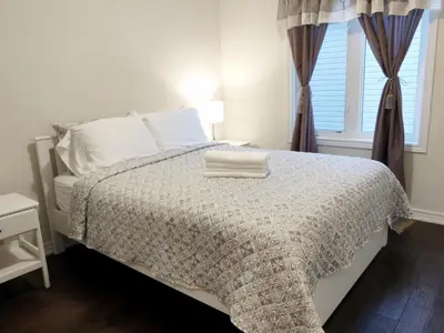 a bedroom with a bed and a window at Home Pearl B&B in Niagara Falls