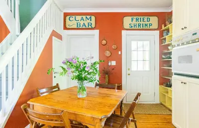 a dining room with a table with a vase of flowers at The River Farmhouse in Corbyville