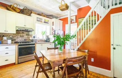 a kitchen with a wooden table and chairs at The River Farmhouse in Corbyville