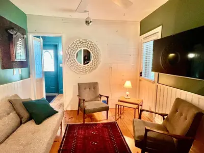 a living room with a couch and a chair and a mirror at The River Farmhouse in Corbyville