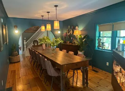 a dining room with a wooden table and chairs at The River Farmhouse in Corbyville