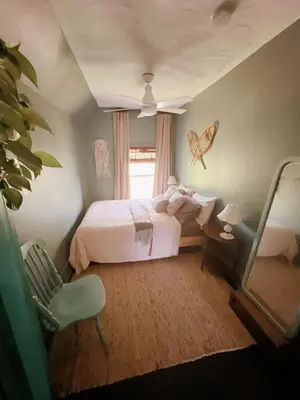 a bedroom with a bed and a chair and a mirror at The River Farmhouse in Corbyville