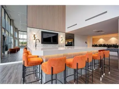 a bar with orange bar stools in a room at 2 Bedroom, 2 Bath Stunning Condo - heart of Kitchener Downtown in Kitchener