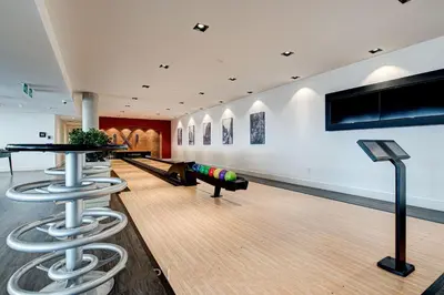 a bowling alley with two bar stools and a table at 2 Bedroom, 2 Bath Stunning Condo - heart of Kitchener Downtown in Kitchener