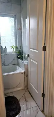 a bathroom with a bath tub and a window at Lilen's Home in Toronto