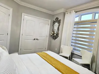 a bedroom with a bed and two chairs and a window at Lilen's Home in Toronto