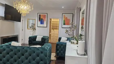 a living room with two blue chairs and a chandelier at Lilen's Home in Toronto