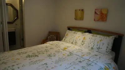 a bedroom with a bed with a floral comforter at Margie Townhome Suites in Toronto