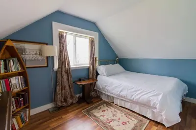 a bedroom with blue walls and a bed with a window at Wine Country 4 bedrooms in Wellington