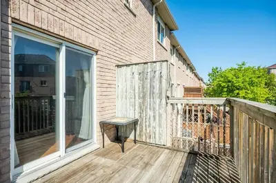 a wooden deck with a bench on the side of a building at Beautiful Townhouse In Toronto in Toronto
