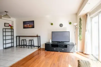 a living room with a flat screen tv and a table at Beautiful Townhouse In Toronto in Toronto