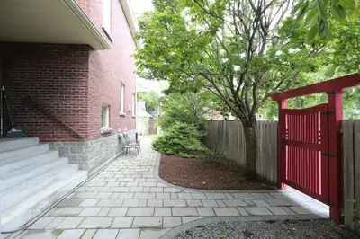 a brick house with a red gate and a fence at Phoebe Wang in Toronto