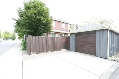 a house with a wooden fence and a garage at Phoebe Wang in Toronto