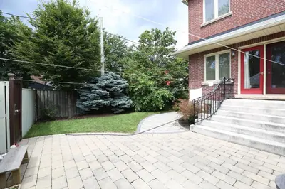 a brick house with a paver driveway in a yard at Phoebe Wang in Toronto