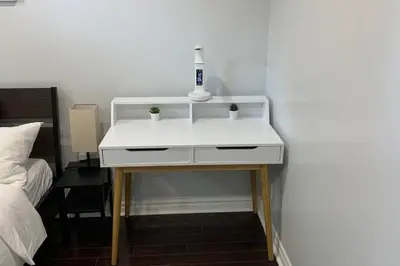 a white table with a bottle on it next to a bed at *Cozy, newly renovated, fully equipped* in Hamilton