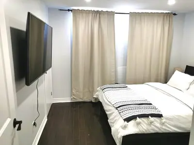 a bedroom with a bed and a flat screen tv at *Cozy, newly renovated, fully equipped* in Hamilton