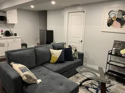 a living room with a gray couch and a glass table at *Cozy, newly renovated, fully equipped* in Hamilton