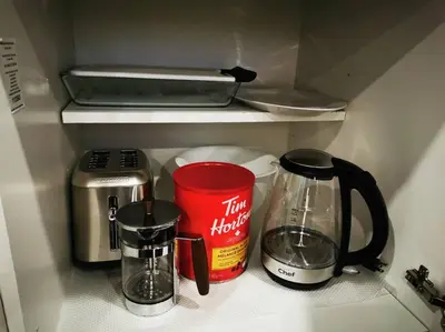a kitchen counter with a coffee maker and a coffee pot at *Cozy, newly renovated, fully equipped* in Hamilton