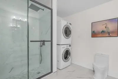 a bathroom with a shower and a washing machine at Beautiful Lakeside Haven in Port Hope