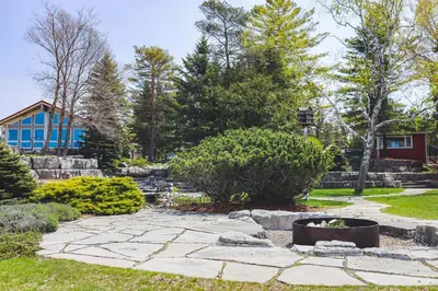 a garden with a stone patio and a house at The Gardenhouse Cottage One in Wasaga Beach
