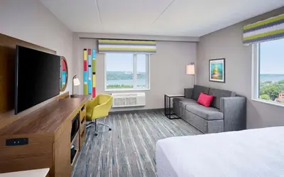 a hotel room with a bed and a flat screen tv at Hampton Inn By Hilton Hamilton in Hamilton