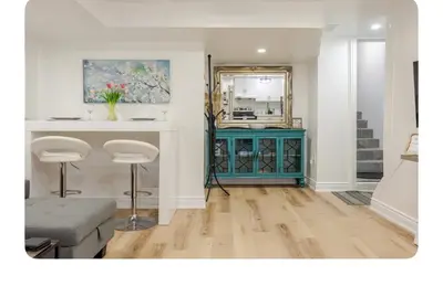 a living room with a blue cabinet and a mirror at LUXURIOUS 1000 SQ FT Oasis in Brampton