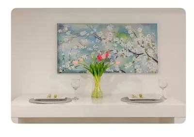 a table with two plates and a vase with pink flowers at LUXURIOUS 1000 SQ FT Oasis in Brampton