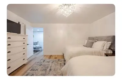 a bedroom with two beds and a dresser with a tv at LUXURIOUS 1000 SQ FT Oasis in Brampton
