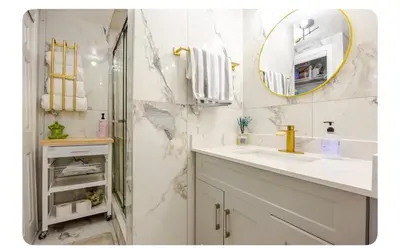 a white bathroom with a sink and a mirror at LUXURIOUS 1000 SQ FT Oasis in Brampton