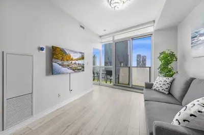 a living room with a couch and a large window at Luxury Downtown Toronto 2 Bedroom Suite with City and Lake Views and Free Parking in Toronto
