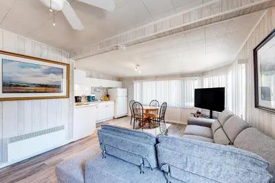 a living room with two blue couches and a kitchen at The Dockhouse Cottage Five in Wasaga Beach