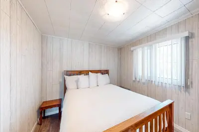 a bedroom with a bed and a window at The Dockhouse Cottage Five in Wasaga Beach