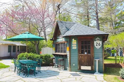 a small play house with a table and an umbrella at The Lighthouse Cottage Four in Wasaga Beach