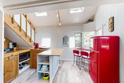 a kitchen with a red refrigerator and wooden floors at The Lighthouse Cottage Four in Wasaga Beach