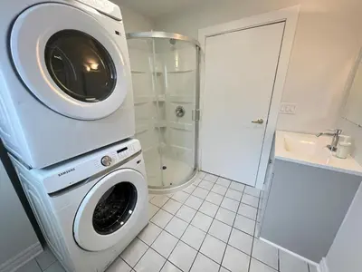 a washing machine in a bathroom with a shower at Letitia Heights !A Spacious and Quiet Private Bedroom with Shared Bathroom in Barrie