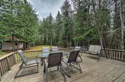 a wooden deck with a table and chairs on it at Lovely waterfront private cottage with hot tub in Kawartha Lakes in Head Lake