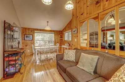 a living room with a couch and a dining room at Lovely waterfront private cottage with hot tub in Kawartha Lakes in Head Lake