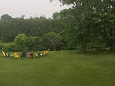 a group of chairs sitting in the grass in a field at Hidden Farm Escape in the Heart of Kawarthas in Beaverton
