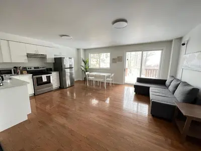 a large living room with a couch and a kitchen at Letitia Heights !B Spacious and Quiet Private Bedroom with Shared Bathroom in Barrie