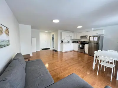 a living room with a couch and a table and a kitchen at Letitia Heights !B Spacious and Quiet Private Bedroom with Shared Bathroom in Barrie