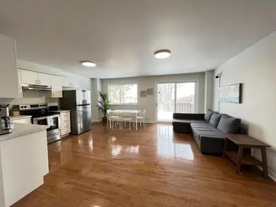 a large living room with a couch and a kitchen at Letitia Heights !B Spacious and Quiet Private Bedroom with Shared Bathroom in Barrie