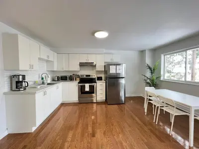 a kitchen with white cabinets and a table with chairs at Letitia Heights !B Spacious and Quiet Private Bedroom with Shared Bathroom in Barrie