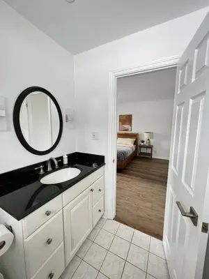 a bathroom with a sink and a mirror and a bed at Letitia Heights !E Spacious and Quiet Private Bedroom with Private Bathroom in Barrie