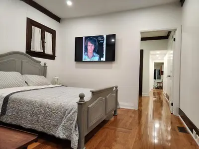 a bedroom with a bed and a television on the wall at Classic Home in Niagara Falls